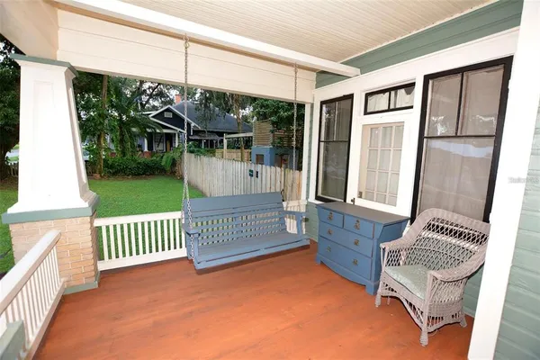 a view of a backyard with a slide trees and wooden fence