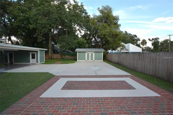 a view of a house with backyard and sitting area