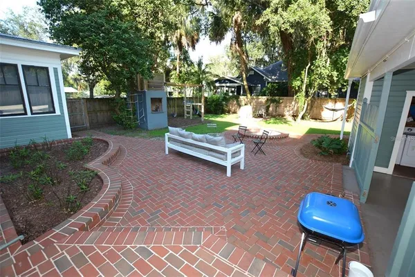 a kitchen with stainless steel appliances a dining table chairs refrigerator and sink
