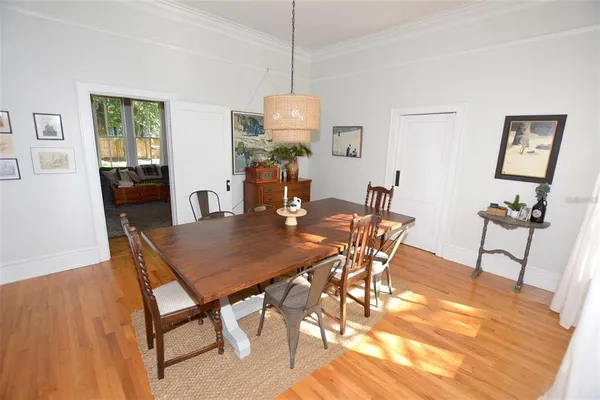 a bedroom with a bed a chandelier and a dresser