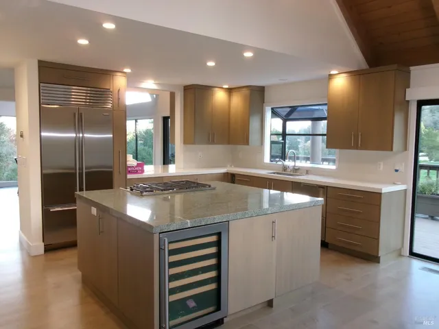a kitchen with stainless steel appliances granite countertop a sink and a refrigerator