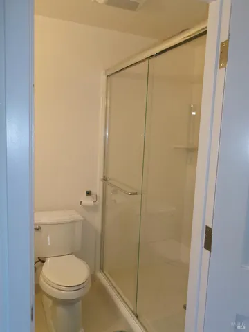 a white toilet sitting next to a shower