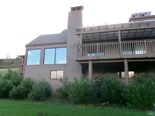 a view of a roof deck with table and chairs and wooden fence