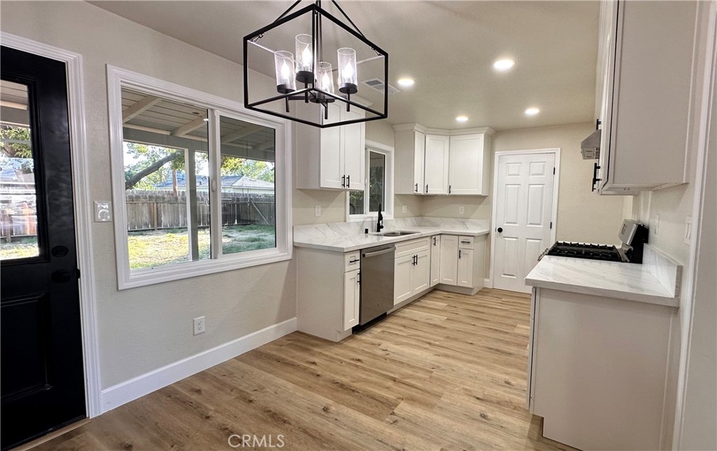 2404 Miller Avenue Modesto, CA 95354 - Photo 5 of 15 a kitchen with kitchen island granite countertop a stove a sink a center island and windows