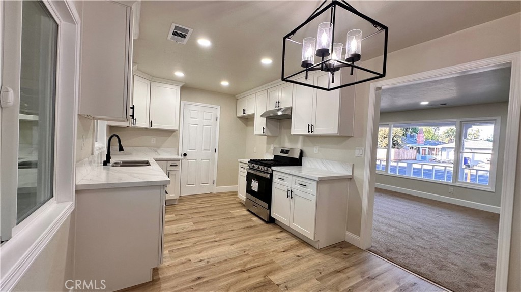 2404 Miller Avenue Modesto, CA 95354 - Photo 6 of 15 a kitchen with stainless steel appliances granite countertop a sink cabinets a stove and a refrigerator