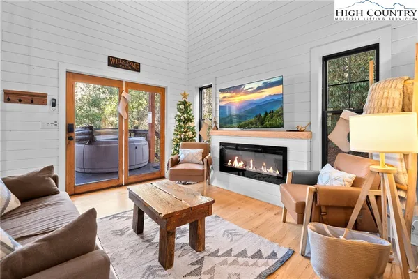 a living room with furniture a flat screen tv and a fireplace