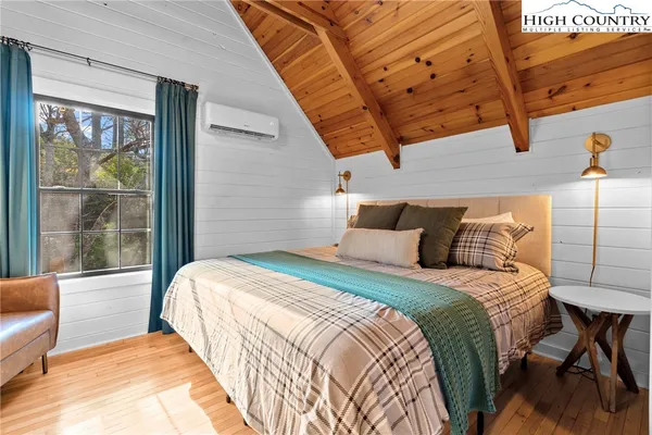 a bed sitting in a bedroom next to a window