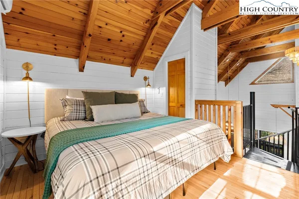 a bedroom with a bed next to a window