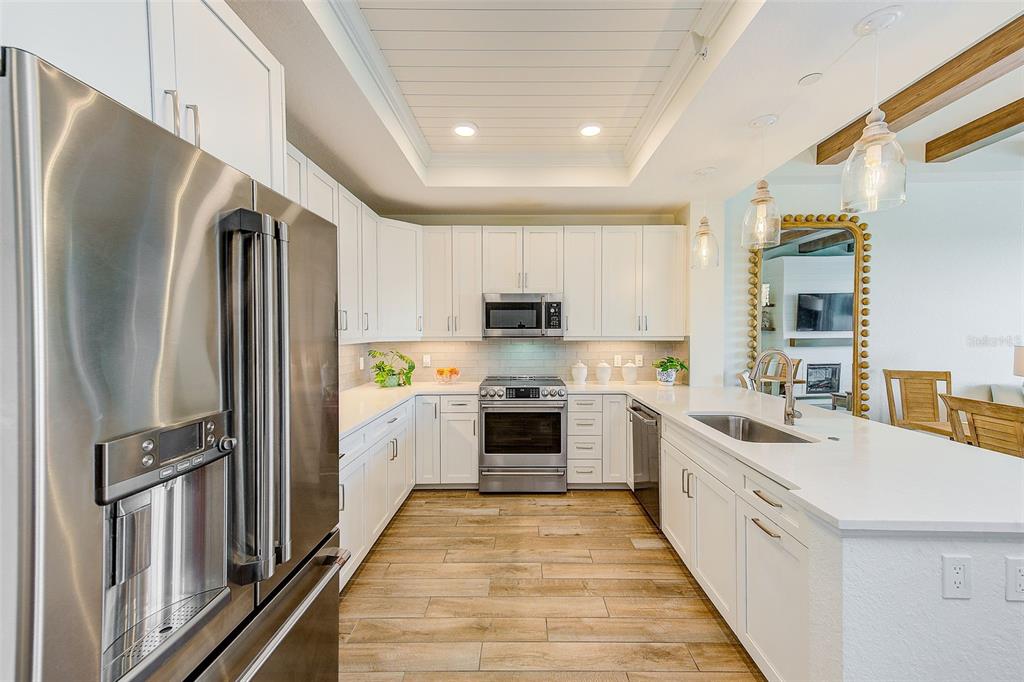 20001 Gulf Boulevard, Unit 403 Indian Shores, FL 33785 - Photo 11 of 43 a kitchen with stainless steel appliances a refrigerator sink and cabinets