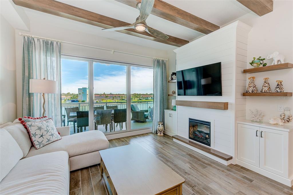 20001 Gulf Boulevard, Unit 403 Indian Shores, FL 33785 - Photo 6 of 43 a living room with furniture a flat screen tv and a fireplace