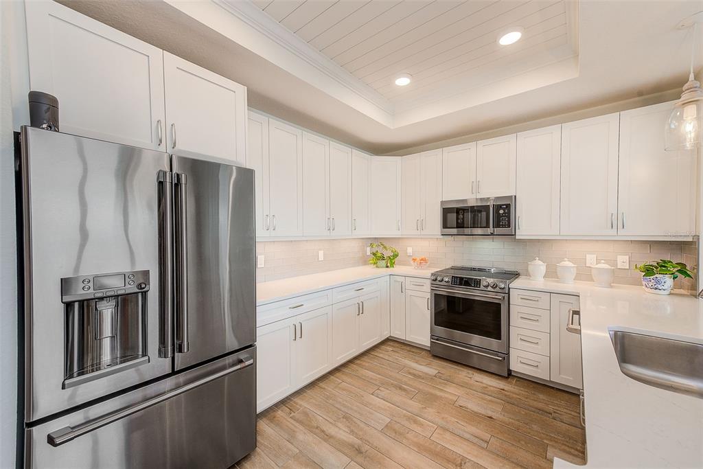 20001 Gulf Boulevard, Unit 403 Indian Shores, FL 33785 - Photo 10 of 43 a kitchen with stainless steel appliances granite countertop a refrigerator stove and sink