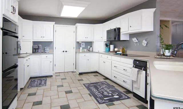 a kitchen with granite countertop a sink a stove and cabinets