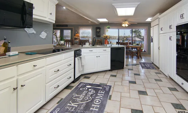 a kitchen with white cabinets and appliances