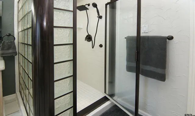 a bathroom with a glass shower door and mirror