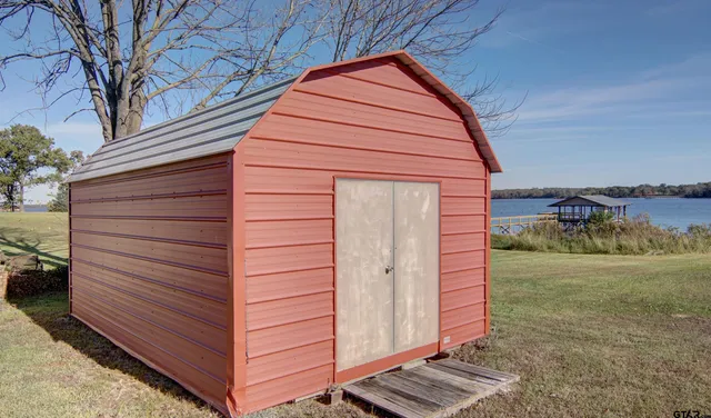 a view of a patio with table and chairs with wooden floor and fence
