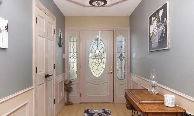 a hallway with painting on the wall and a window