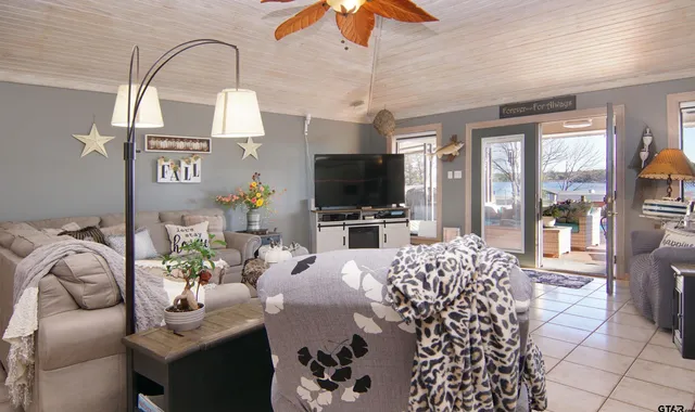 a living room with furniture a flat screen tv and a chandelier