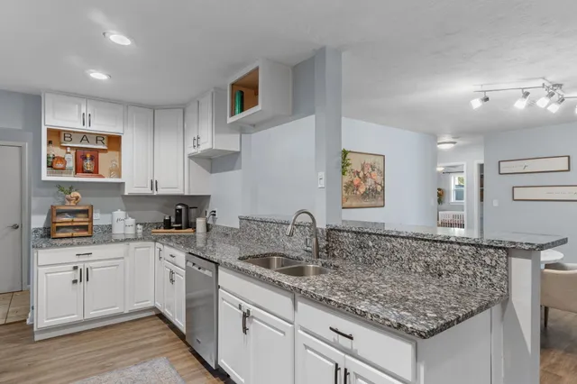 a kitchen with granite countertop a sink and cabinets