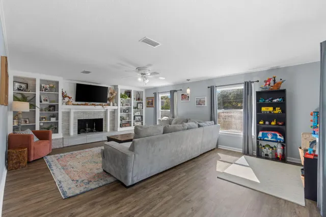 a living room with furniture and a fireplace with wooden floor