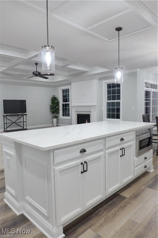 32028 Chestnut Ridge Road North Ridgeville, OH 44039 - Photo 12 of 39 Kitchen featuring stainless steel microwave, coffered ceiling, ceiling fan, and light hardwood / wood-style floors
