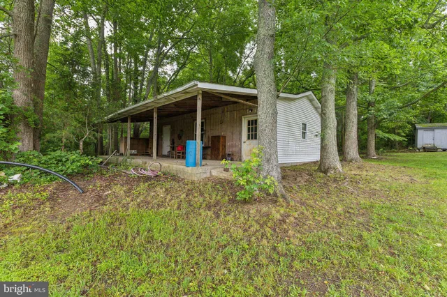 a view of a house with backyard and trees