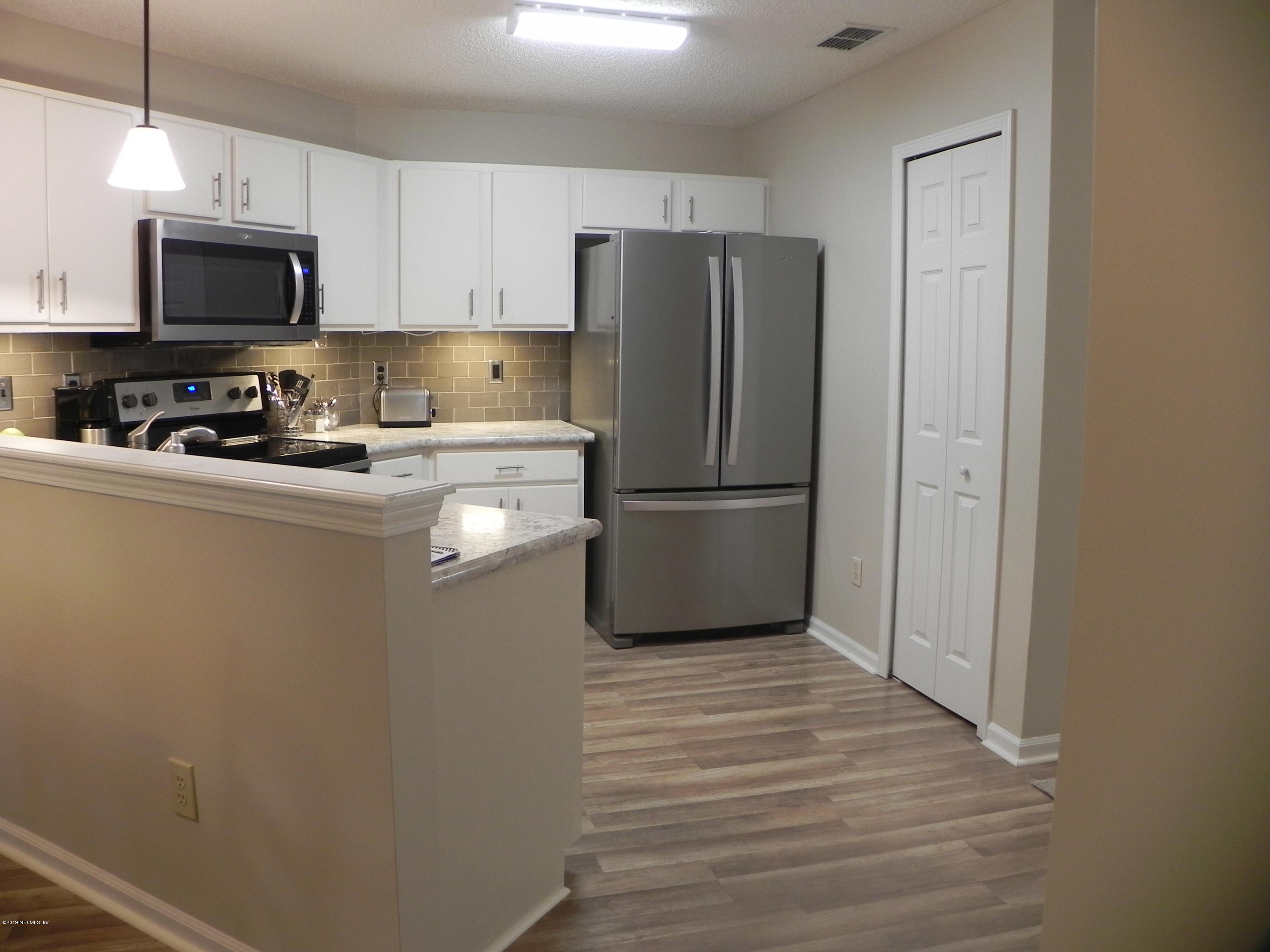 900 Country Bridge Road, Unit 1 Jacksonville, FL 32259 - Photo 8 of 31 a kitchen with a refrigerator a microwave a sink and cabinets