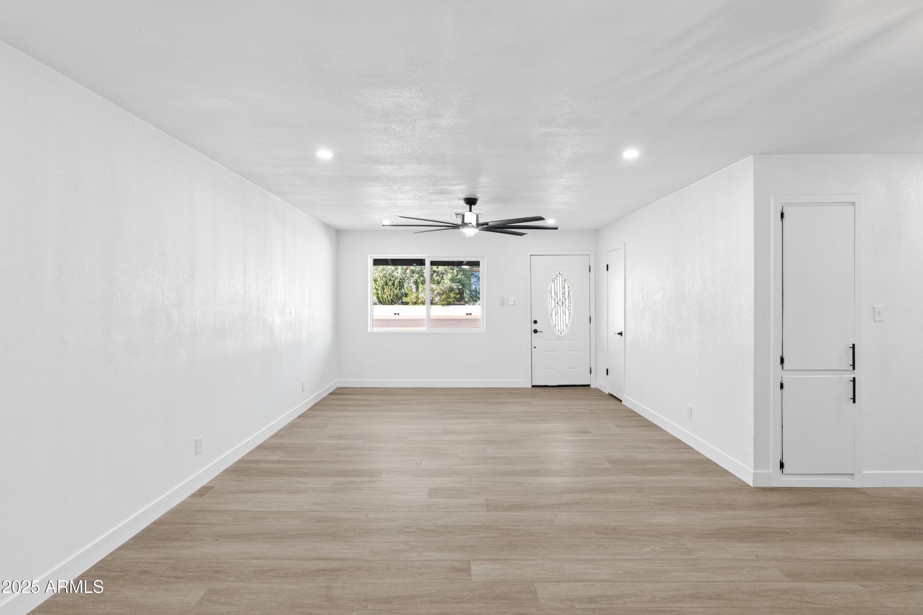 901 West Mercer Lane Phoenix, AZ 85029 - Photo 18 of 40 an empty room with wooden floor and windows