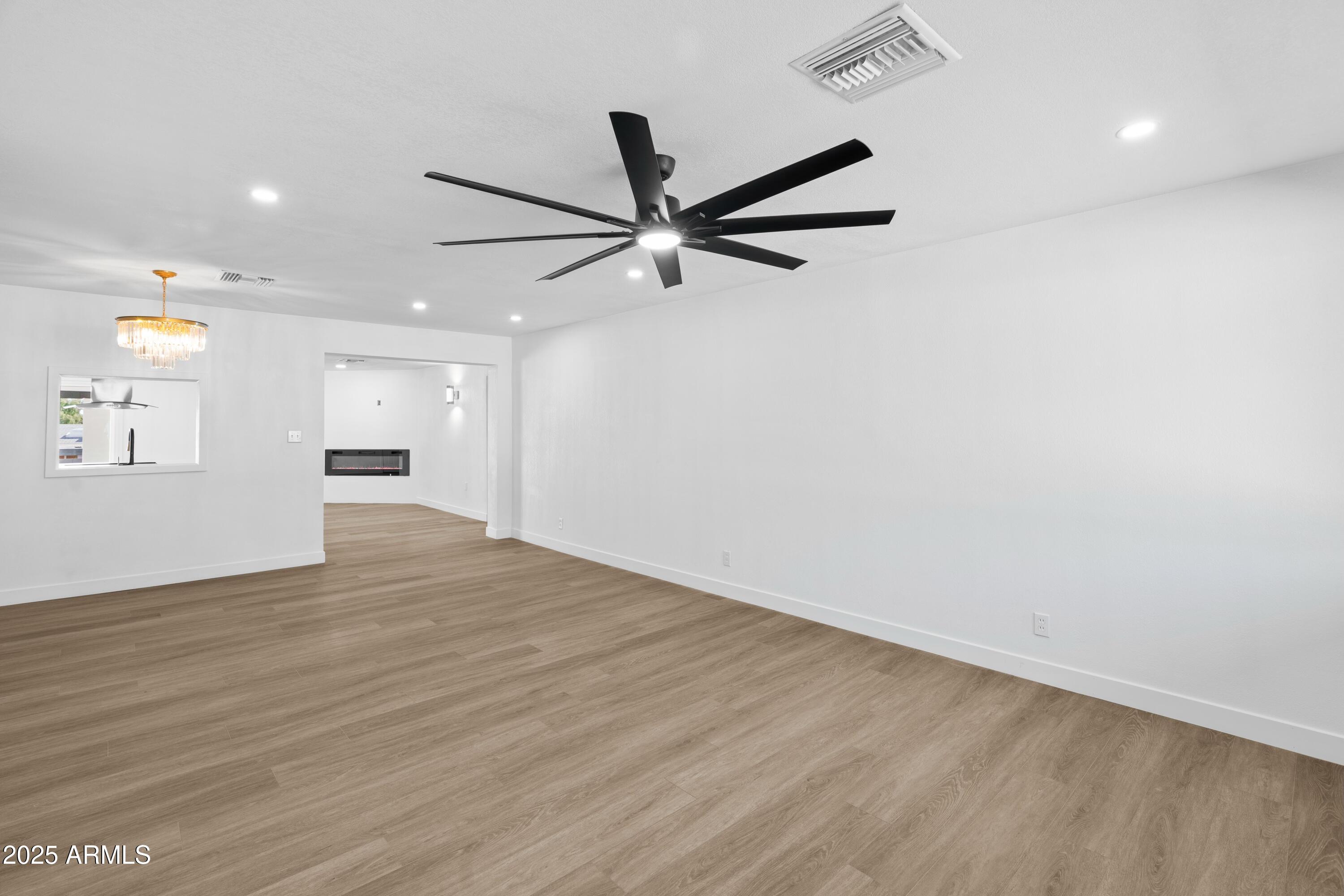 901 West Mercer Lane Phoenix, AZ 85029 - Photo 20 of 40 an empty room with wooden floor and a ceiling fan