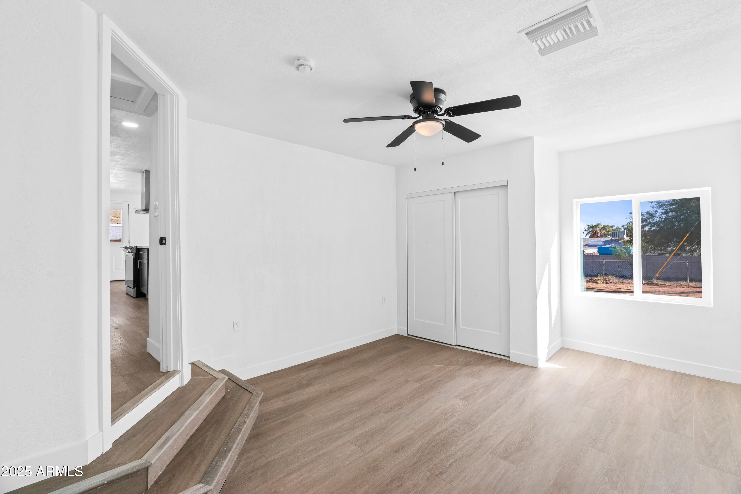 901 West Mercer Lane Phoenix, AZ 85029 - Photo 24 of 40 a view of empty room with wooden floor and fan