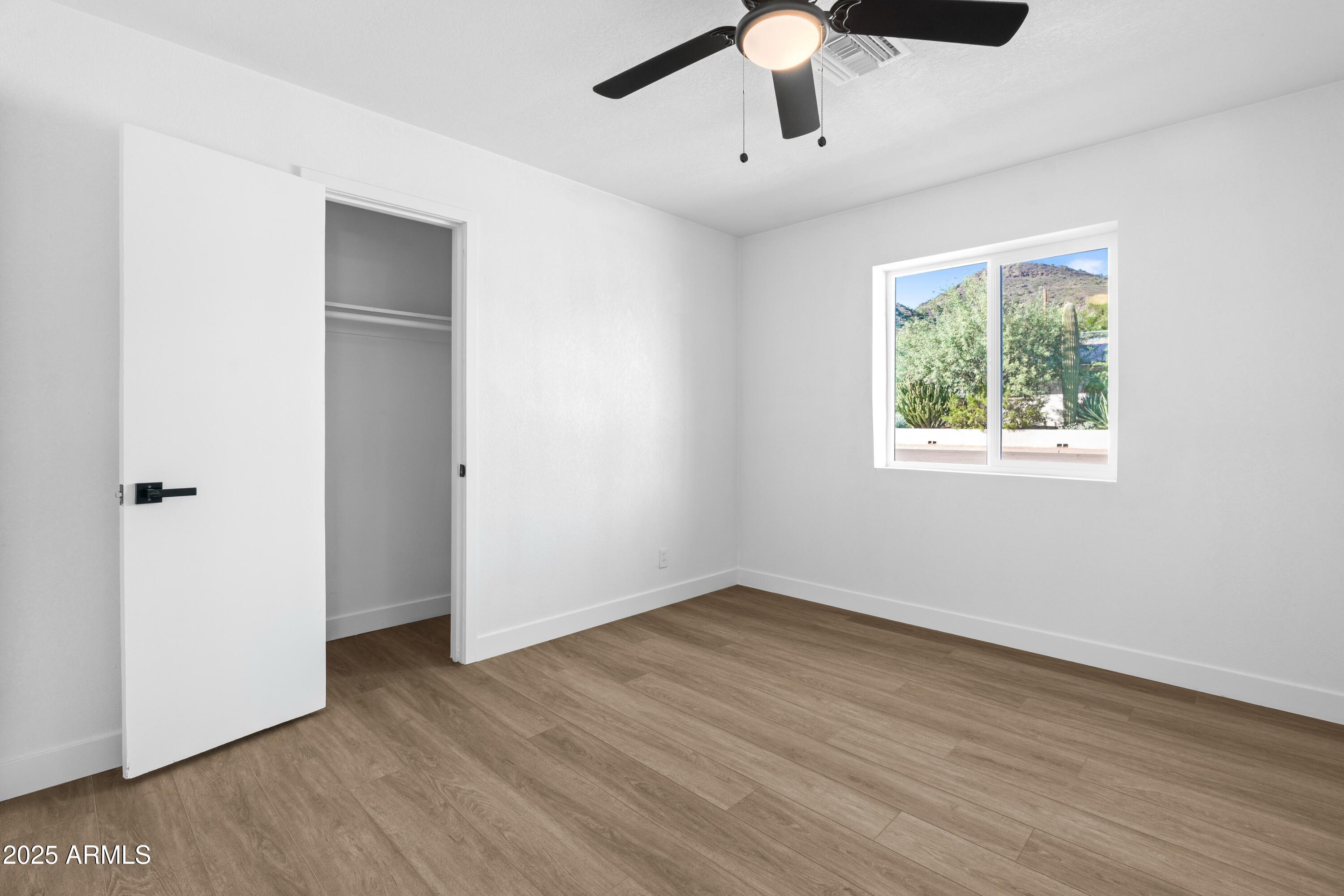 901 West Mercer Lane Phoenix, AZ 85029 - Photo 34 of 40 a view of an empty room with wooden floor and a window
