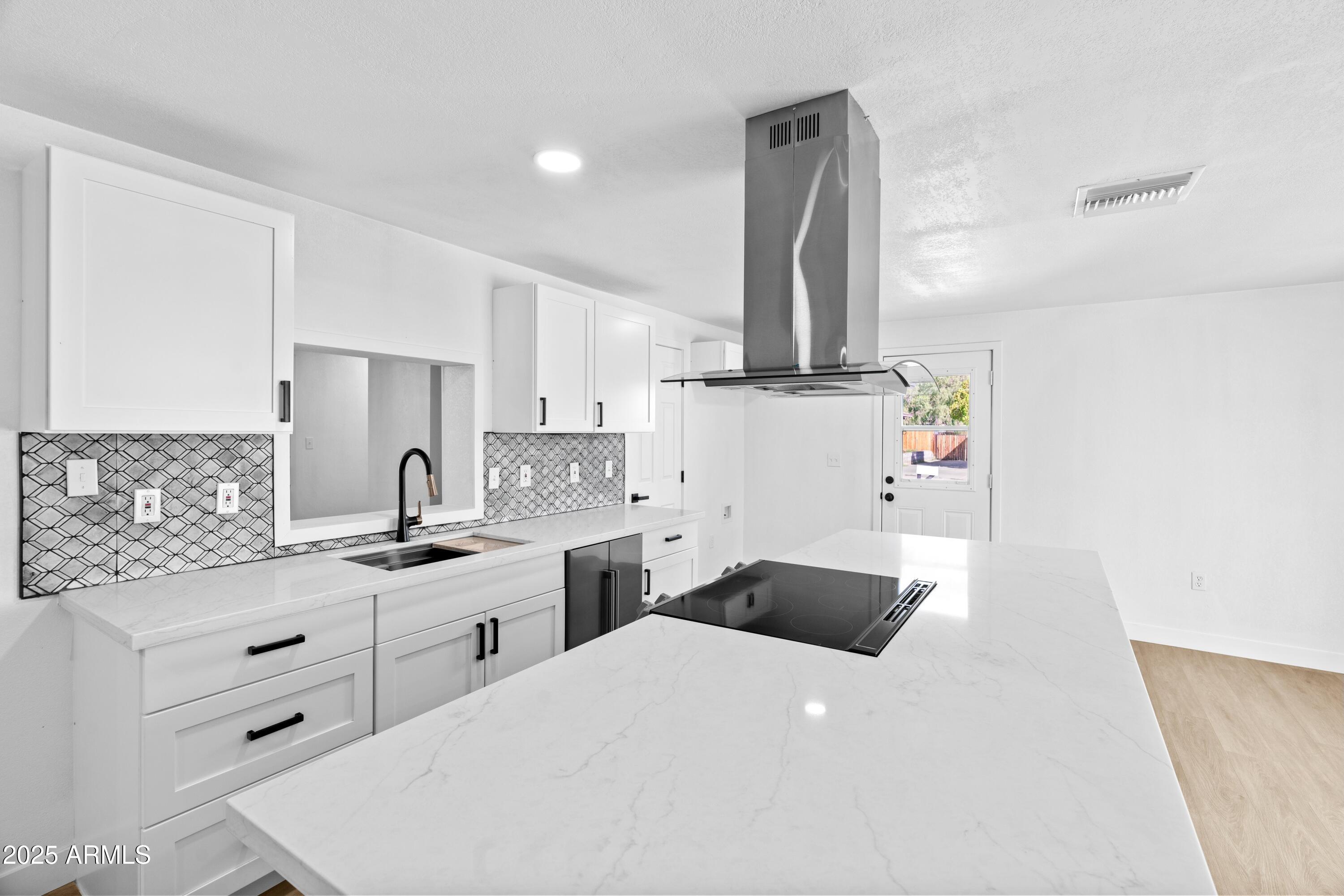 901 West Mercer Lane Phoenix, AZ 85029 - Photo 10 of 40 a kitchen with a sink dishwasher and white cabinets with wooden floor
