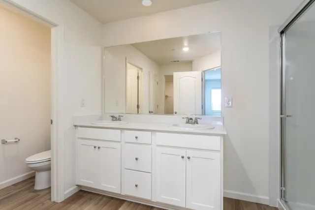 a bathroom with a double vanity sink and a toilet