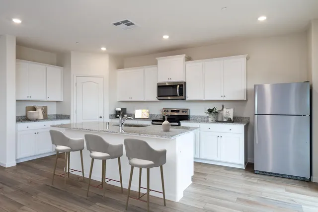 a kitchen with white cabinets and stainless steel appliances