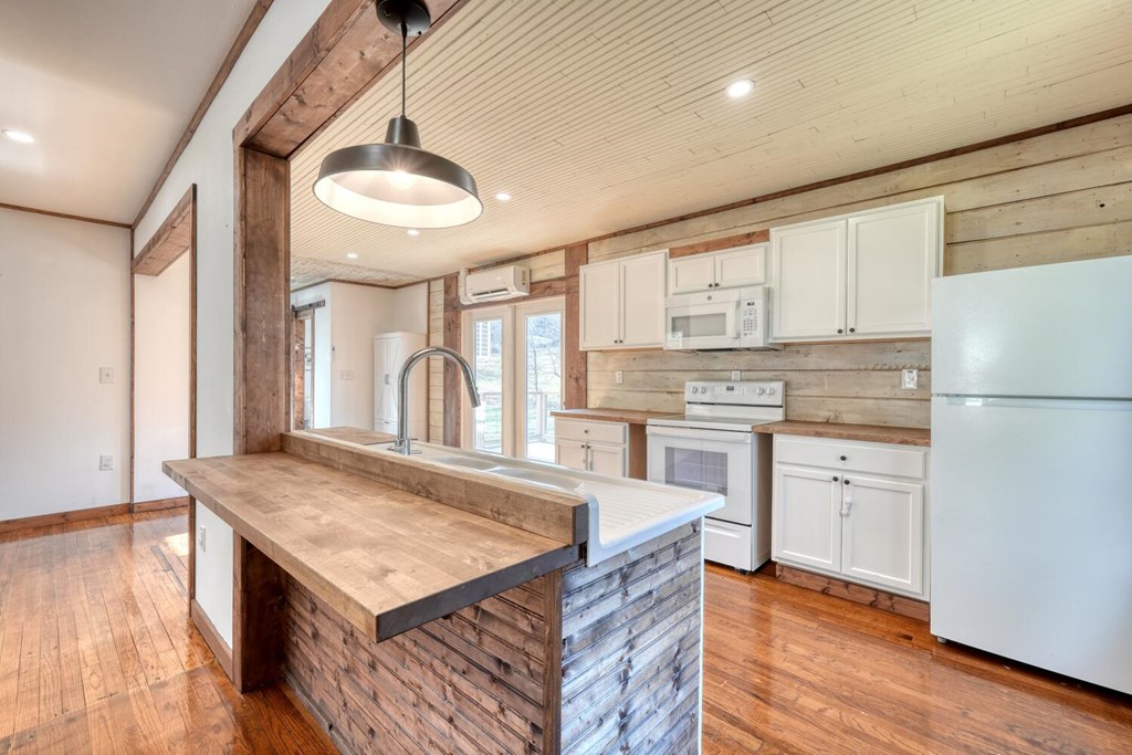 734 Bell Creek Road Hiawassee, GA 30546 - Photo 6 of 30 a kitchen with white cabinets and white appliances
