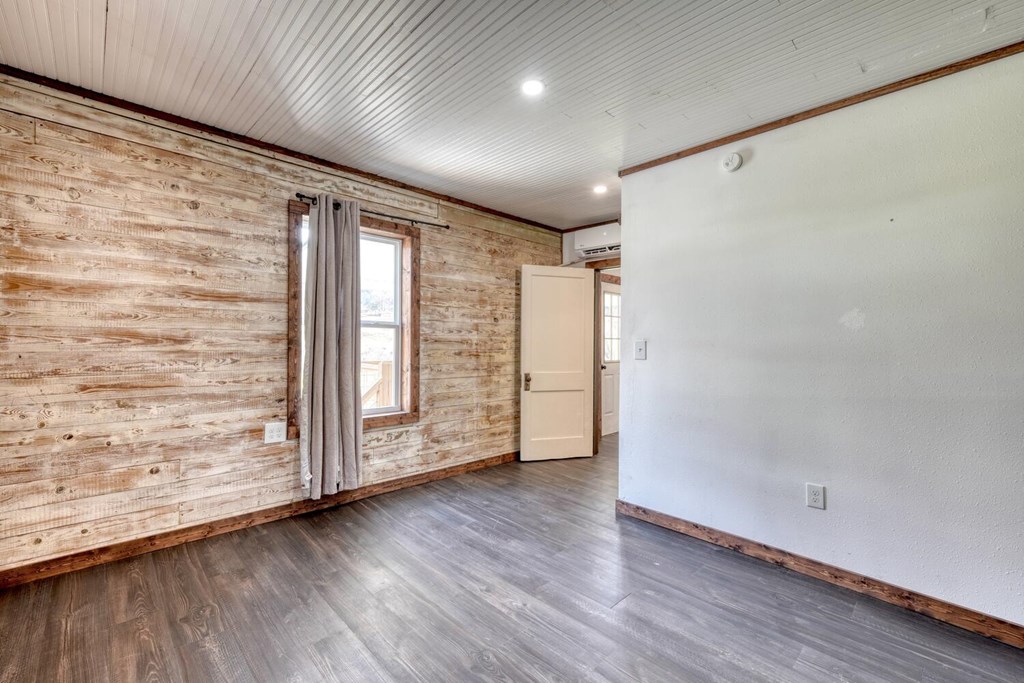 734 Bell Creek Road Hiawassee, GA 30546 - Photo 9 of 30 a view of an empty room with wooden floor and a window