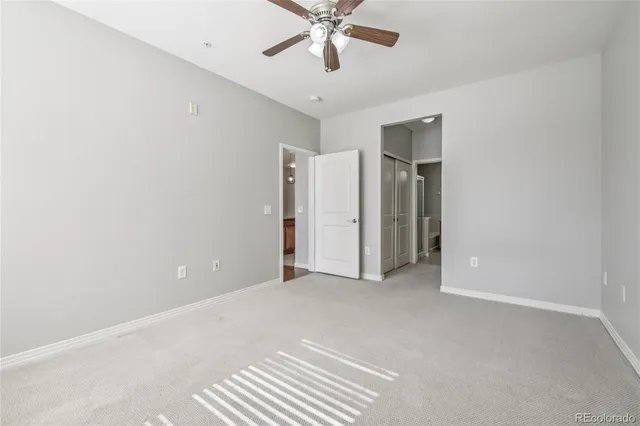 a view of an empty room with a ceiling fan