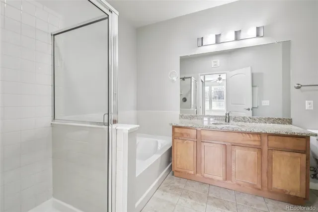 a bathroom with a granite countertop sink a mirror and a bathtub