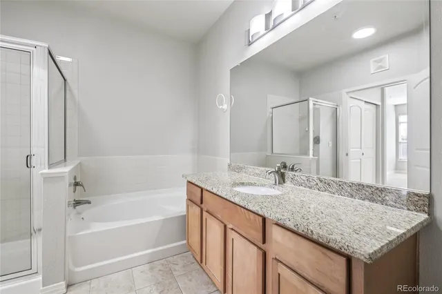 a bathroom with a granite countertop sink and a mirror a bathtub