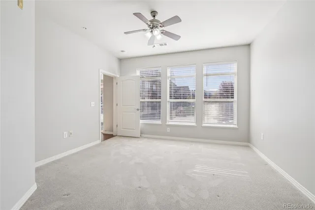 an empty room with a window and a ceiling fan