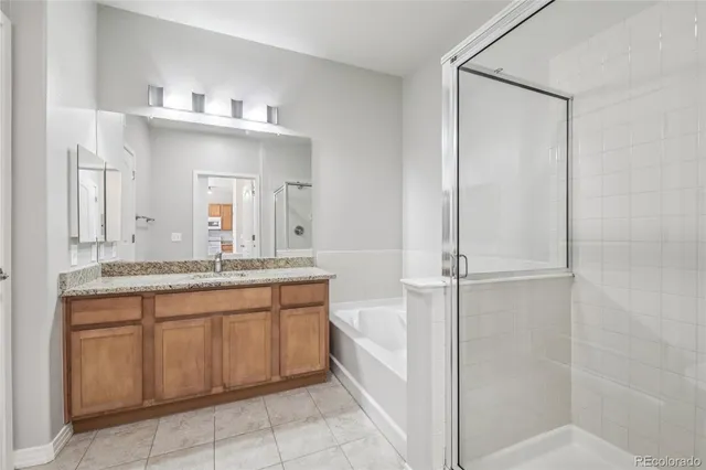 a bathroom with a granite countertop sink mirror and bathtub