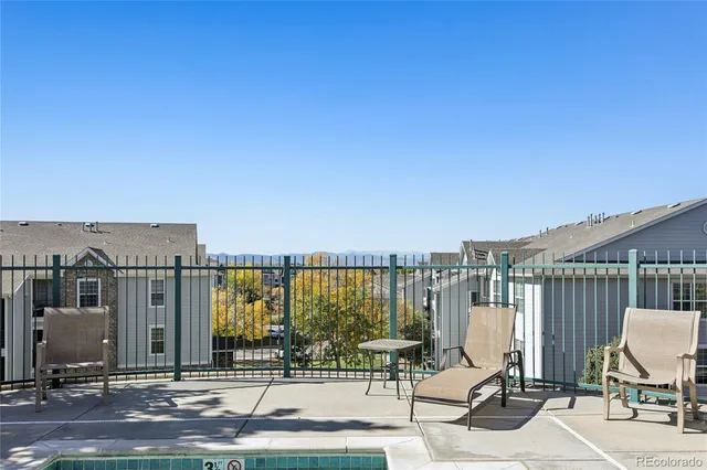 a view of a balcony with chairs and iron fence