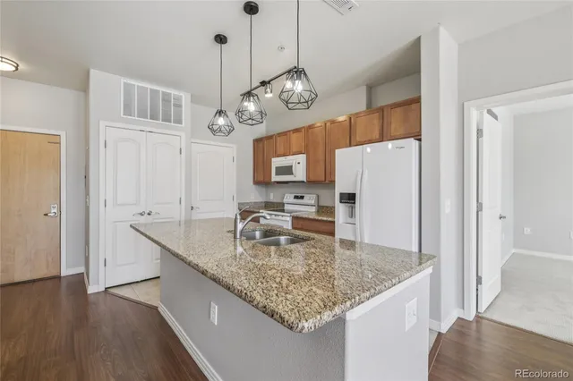 a kitchen with stainless steel appliances granite countertop a sink a refrigerator and a granite counter tops