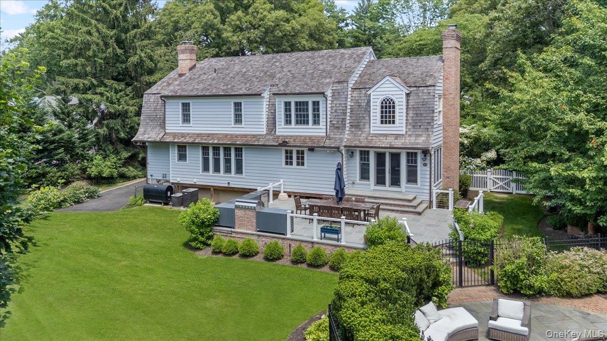 5 Fox Hunt Court Cold Spring Harbor, NY 11724 - Photo 35 of 42 Spacious rear yard featuring a large stone patio, built-in outdoor kitchen, expansive lawn, and mature perimeter landscaping