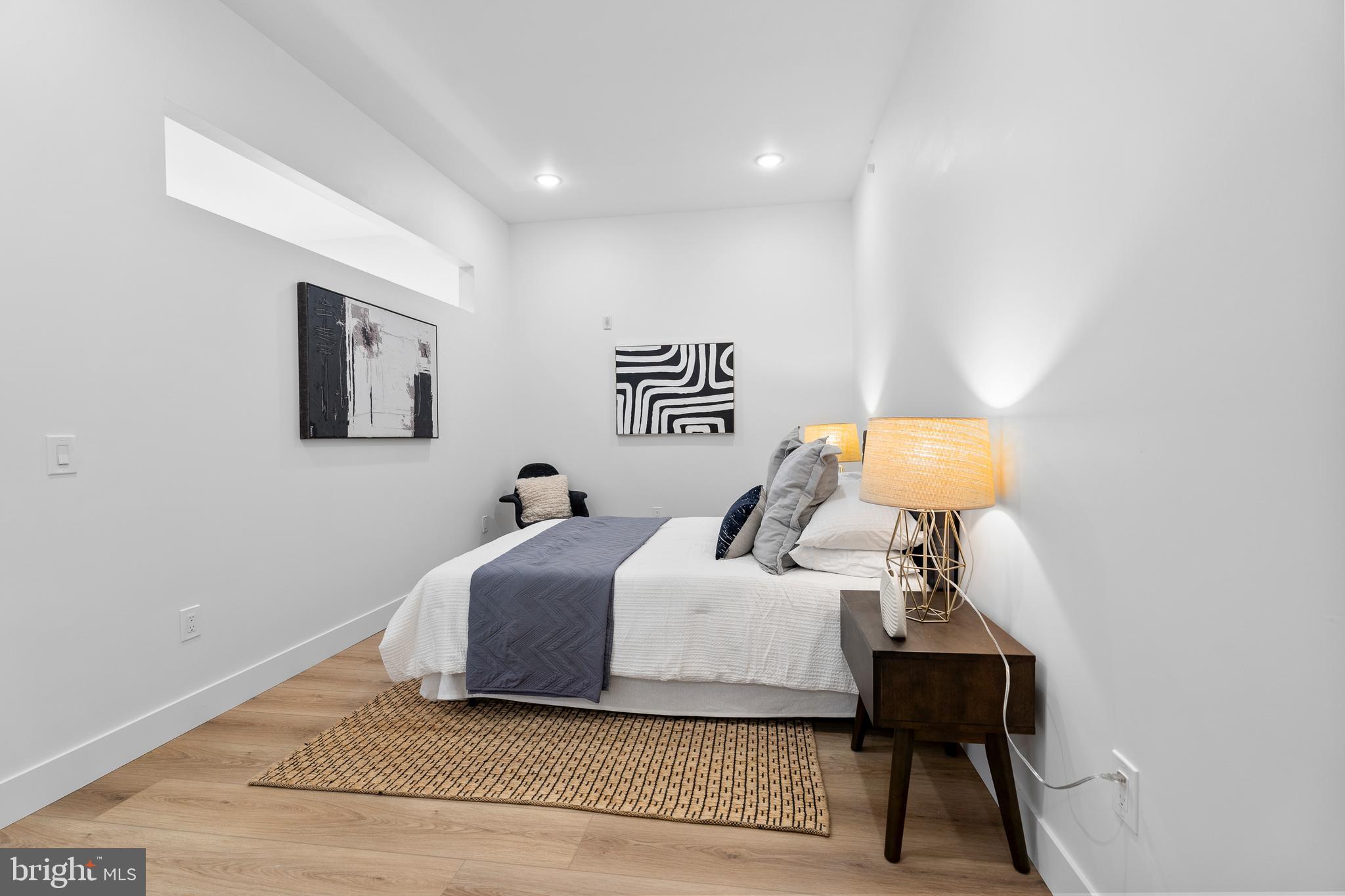 300 Christian Street, Unit 202 Philadelphia, PA 19147 - Photo 12 of 27 a bedroom with a bed and lamp