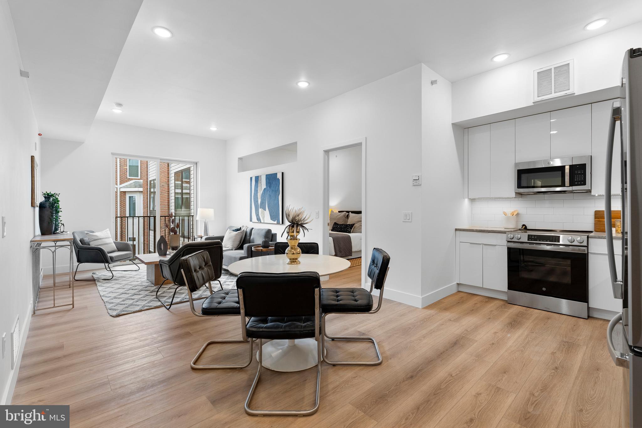 300 Christian Street, Unit 202 Philadelphia, PA 19147 - Photo 4 of 27 a living room with furniture a flat screen tv and kitchen view