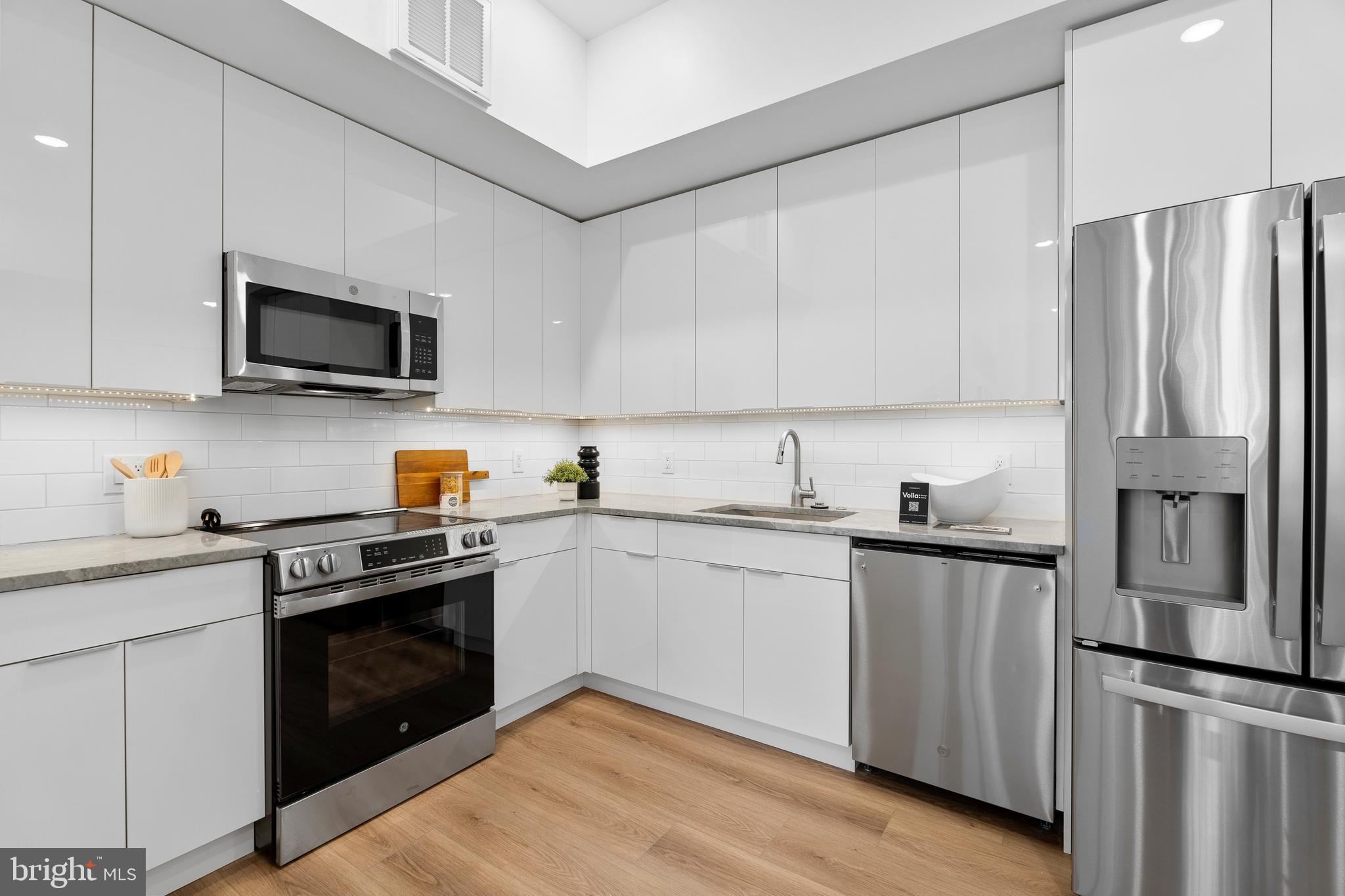 300 Christian Street, Unit 202 Philadelphia, PA 19147 - Photo 8 of 27 a kitchen with stainless steel appliances granite countertop a stove top oven a sink and dishwasher a refrigerator with white cabinets