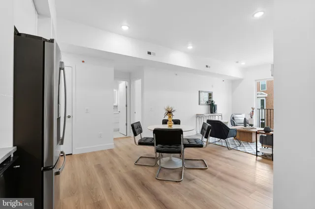 a living room with furniture a wooden floor and a large window