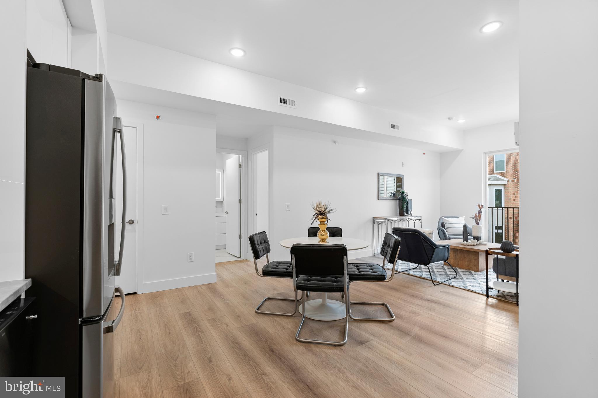 300 Christian Street, Unit 202 Philadelphia, PA 19147 - Photo 9 of 27 a living room with furniture a wooden floor and a large window