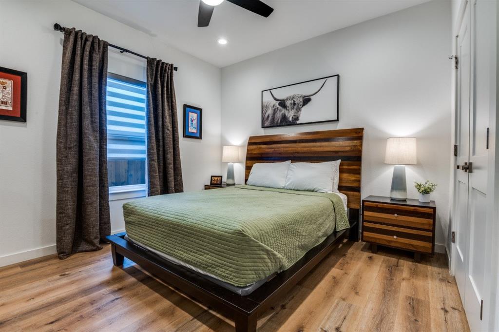 1110 Claude Street Dallas, TX 75203 - Photo 11 of 12 a bedroom with a bed and wooden floor