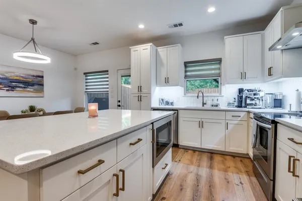 a kitchen with a sink appliances cabinets and a counter top space